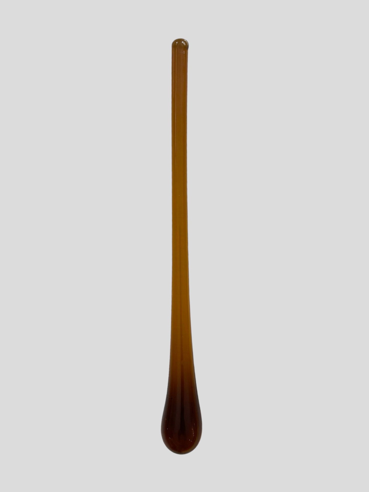 An amber muddler for mixing cocktails.