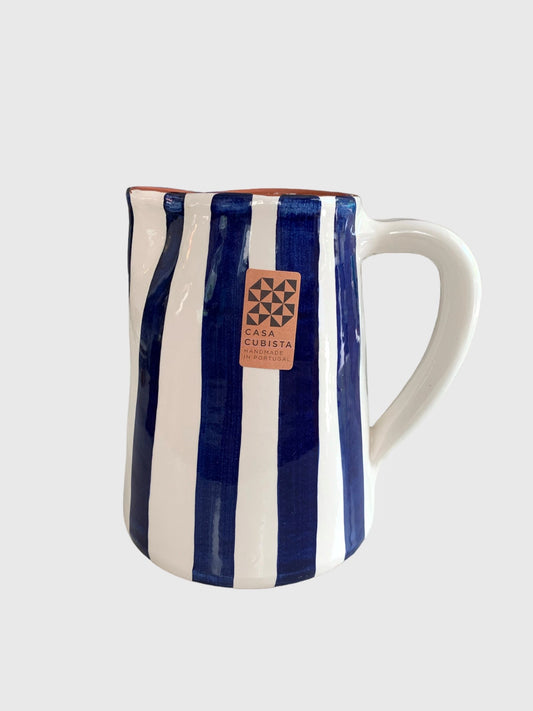 A hand-painted ceramic jug with bold blue and white stripes from Casa Cubista