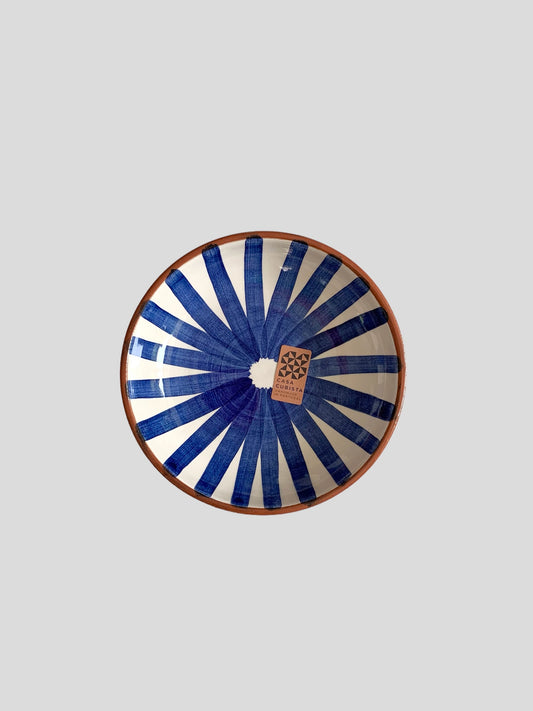 A medium sized ceramic bowl hand-painted with a blue ray design. Made in Portugal from casa cubista