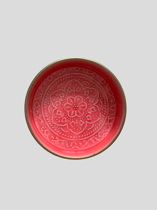 A mini bright pink enamel tray with floral embossing detail.