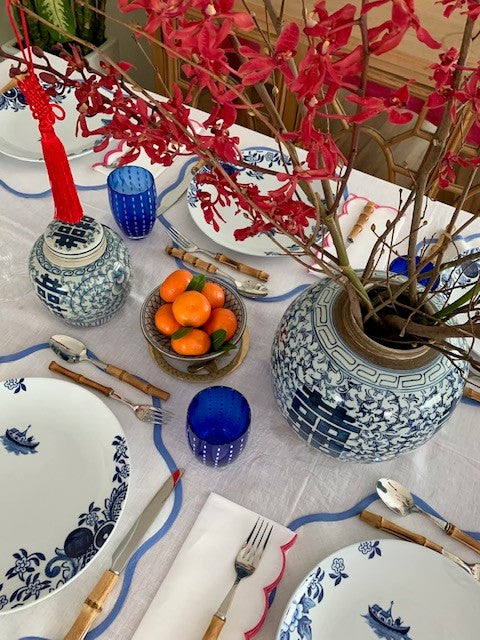 A Chinese New Year table setting featuring one large and one medium double happiness ginger jar as centrepieces.