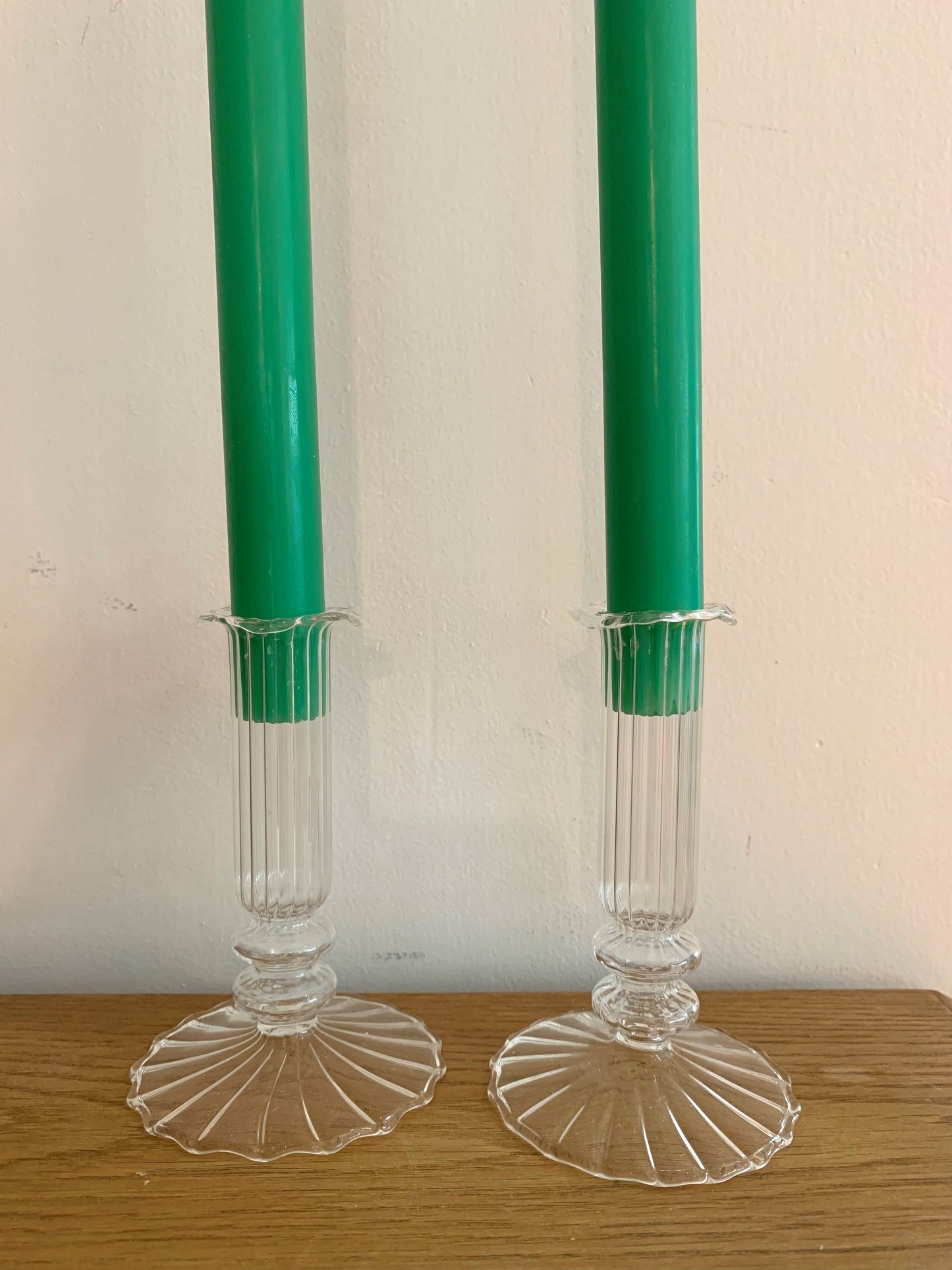 A pair of glass cande holders with two green candles