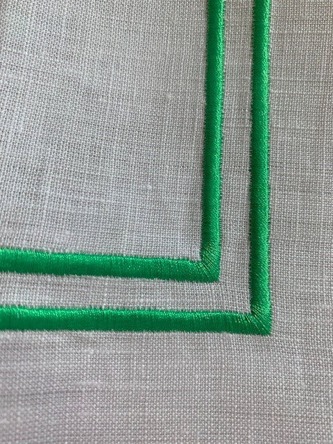 Double green piping on a white linen napkin