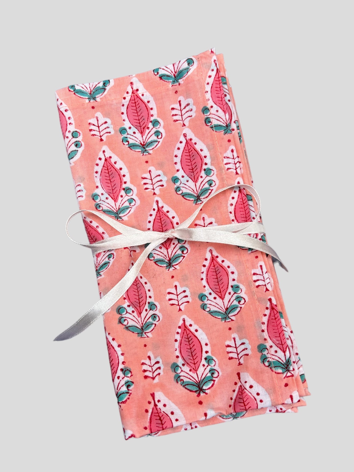 Pink floral blockprinted napkins tied in ribbon.