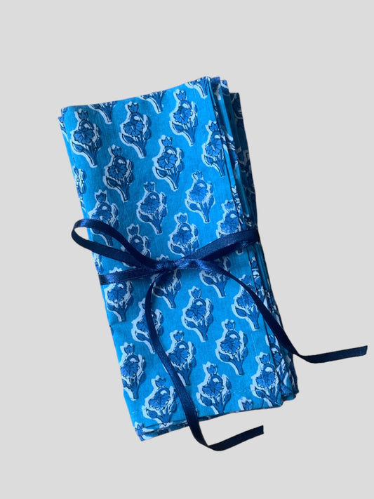 a set of 4 blue floral block printed napkins tied with ribbon.