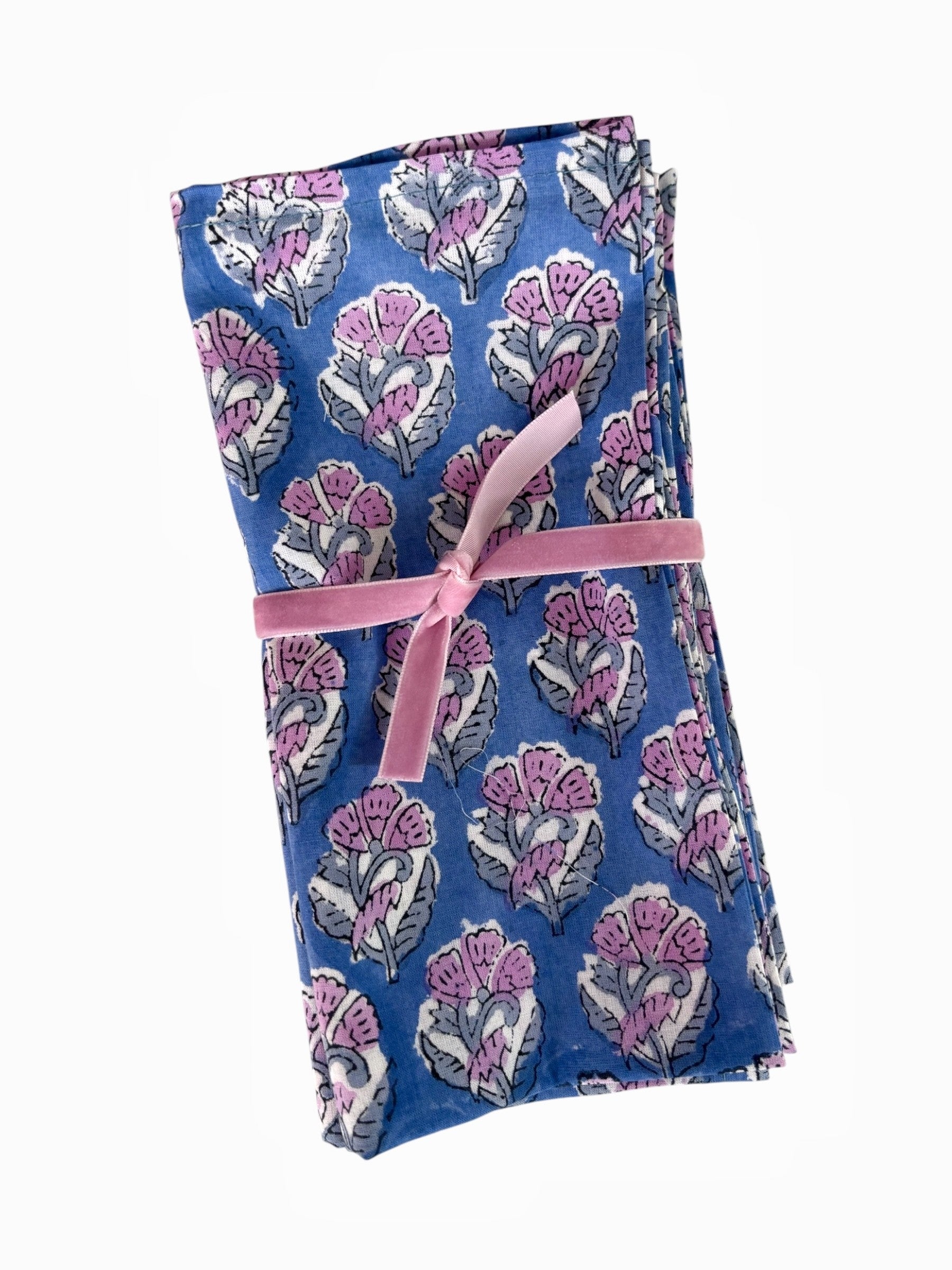 Folded fabric with floral pattern and pink ribbon on a white background