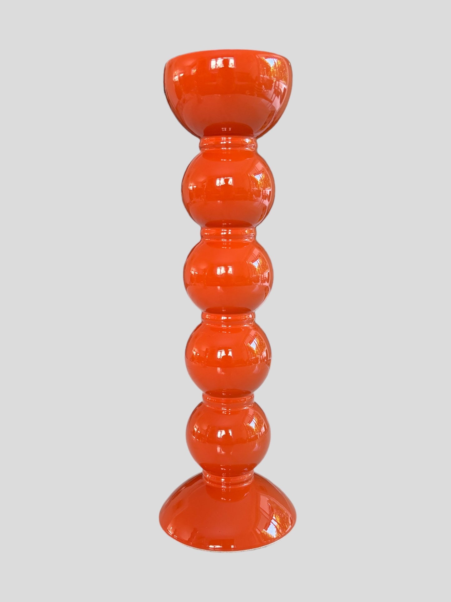 A tall bobbin shaped orange lacquered candlestick from Addisson Ross
