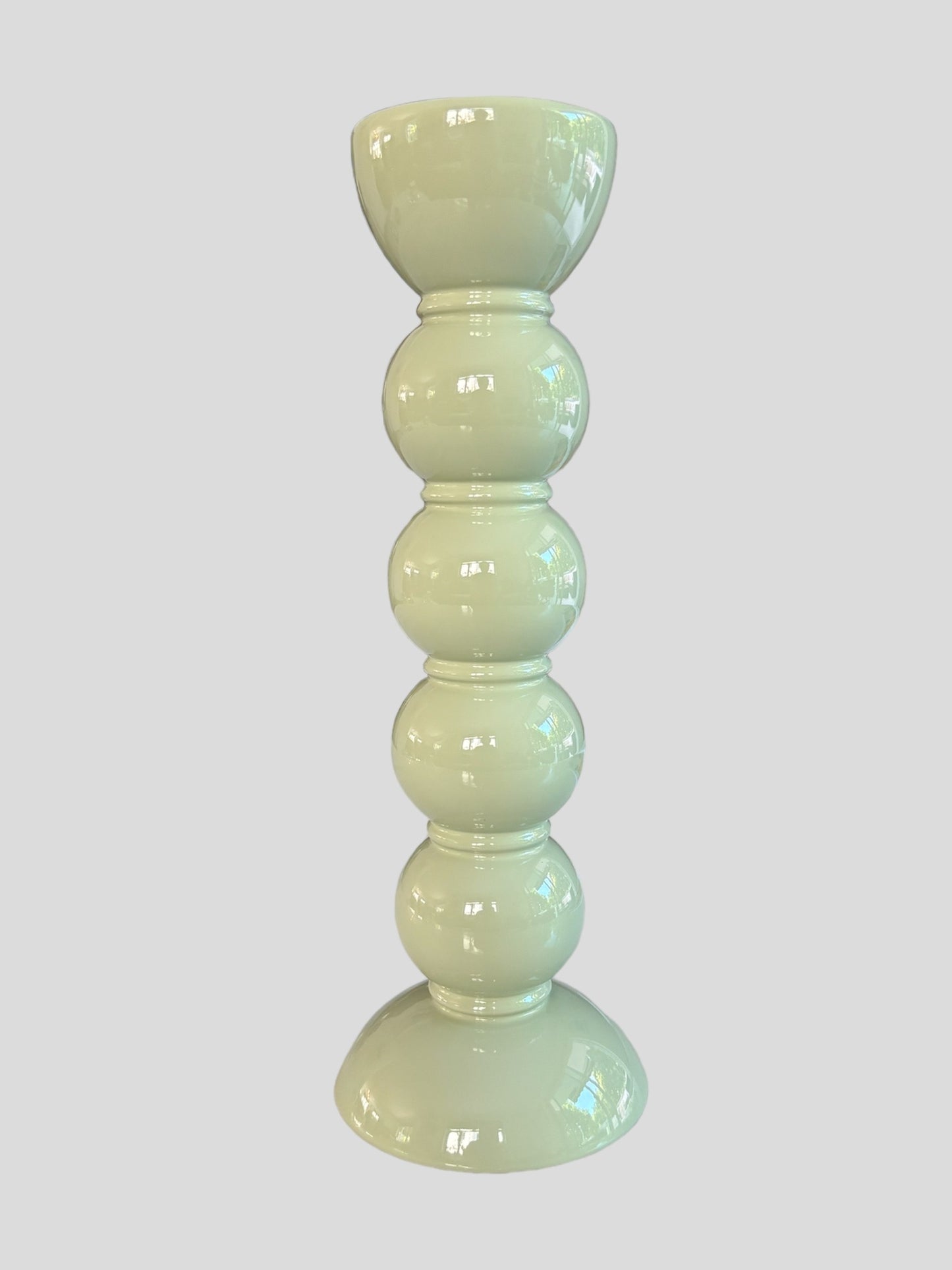 A tall bobbin shaped sage green lacquered candlestick from Addison Ross