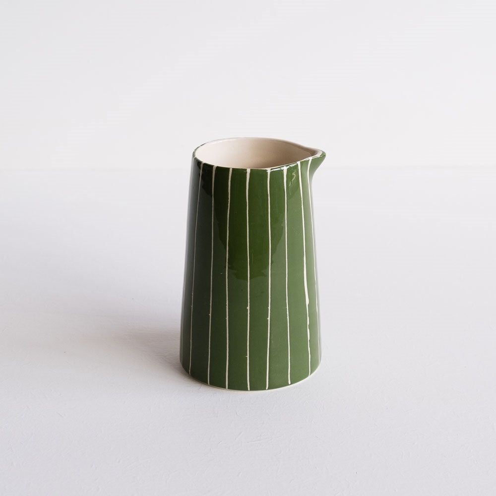 A green and white striped milk jug.  Handmade and hand-painted in Portugal.