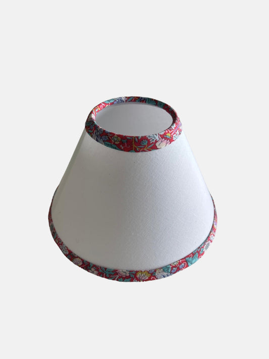 A white lampshade with a red print Liberty trim