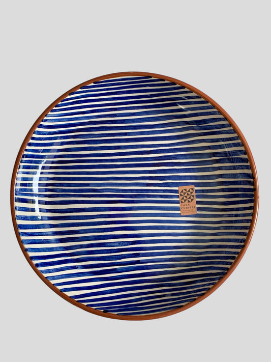 A large ceramic platter hand-painted with blue stripes