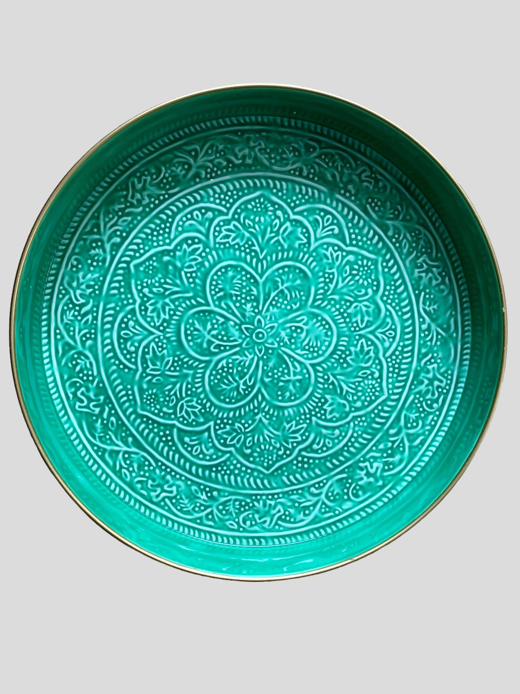 A large round green enamel serving tray with embossed detail