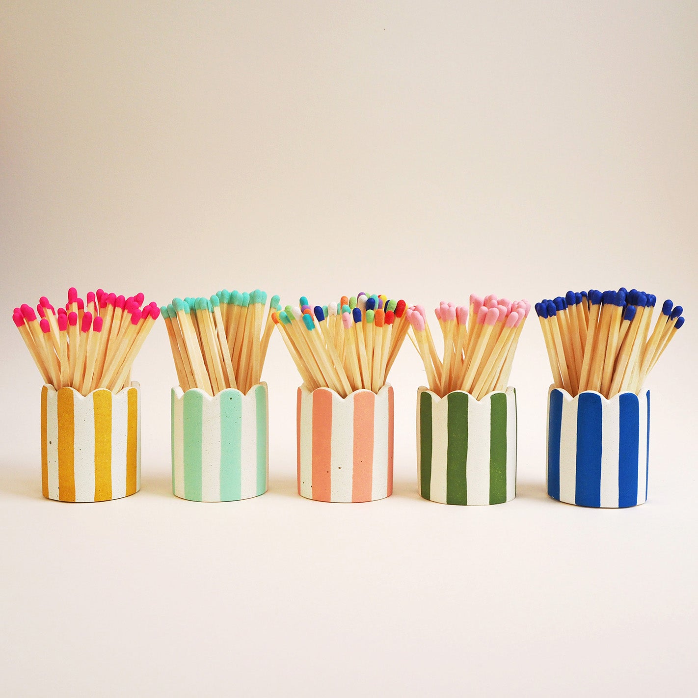 5 brightly coloured stripey matchstick pots with long coloured matches