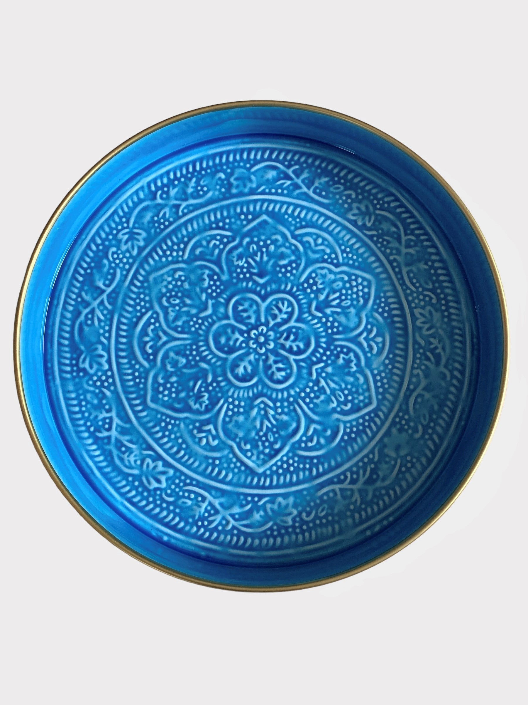 A bright blue enamel tray with floral embossing