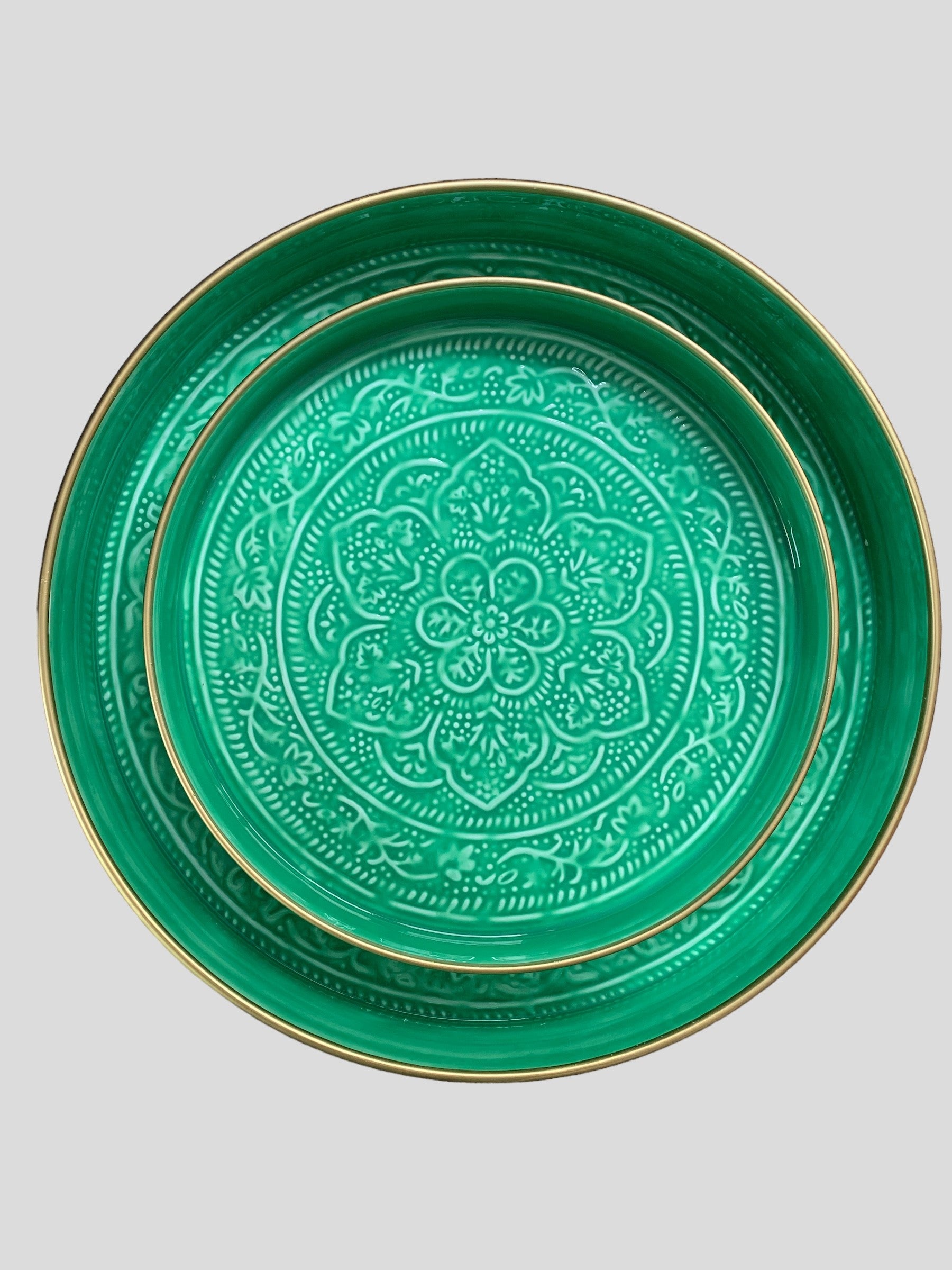 A medium sized bright green enamel tray sitting inside a larger green enamel tray.  The trays have been embossed with a floral pattern.