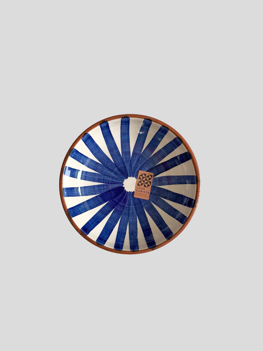 A medium sized ceramic bowl hand-painted with a blue ray design.  Made in Portugal from casa cubista
