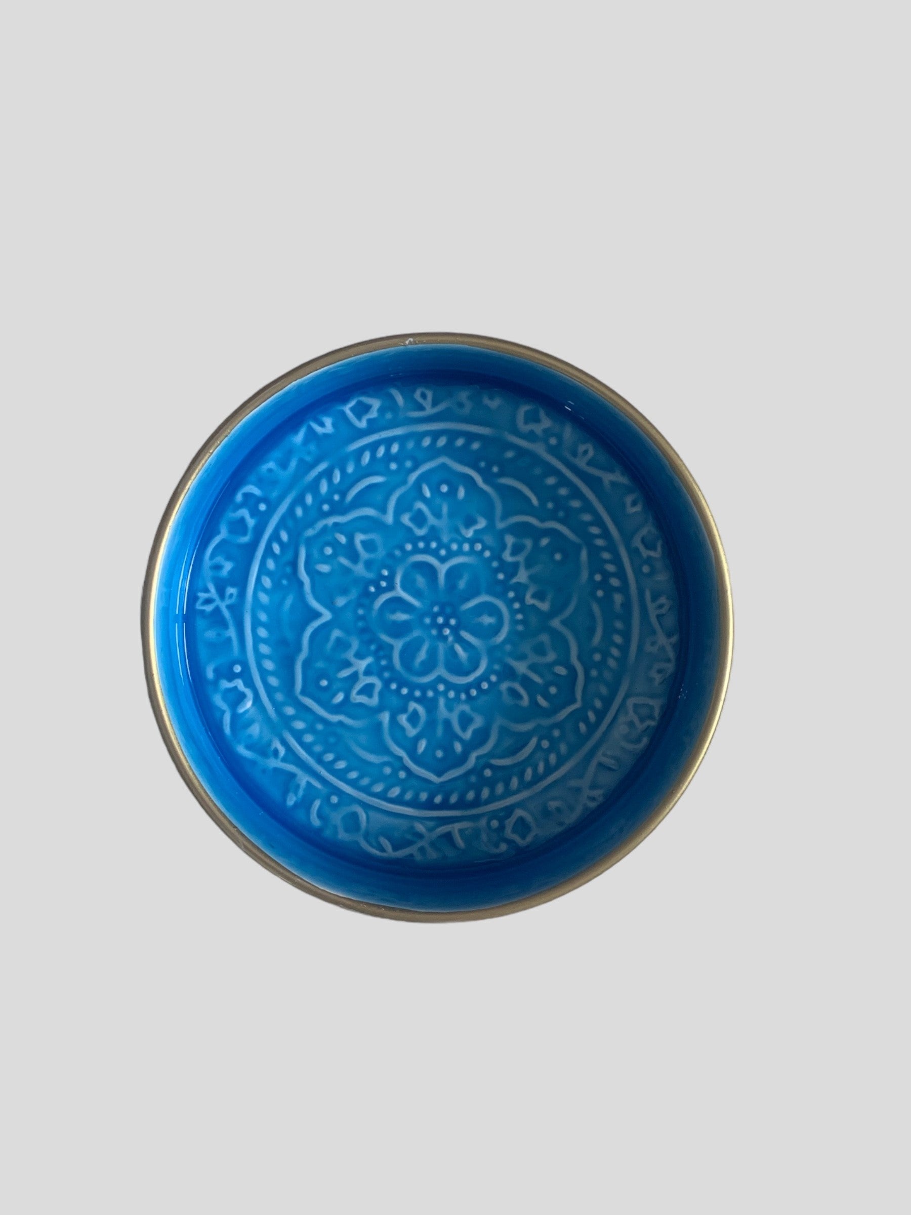 A mini blue enamel tray with floral embossing detail.