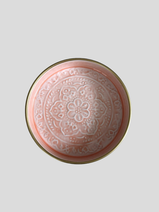 A mini enamel tray in light pink with floral embossed detail.