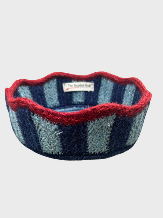 A pale blue and navy striped tulip basket with red scalloped edging