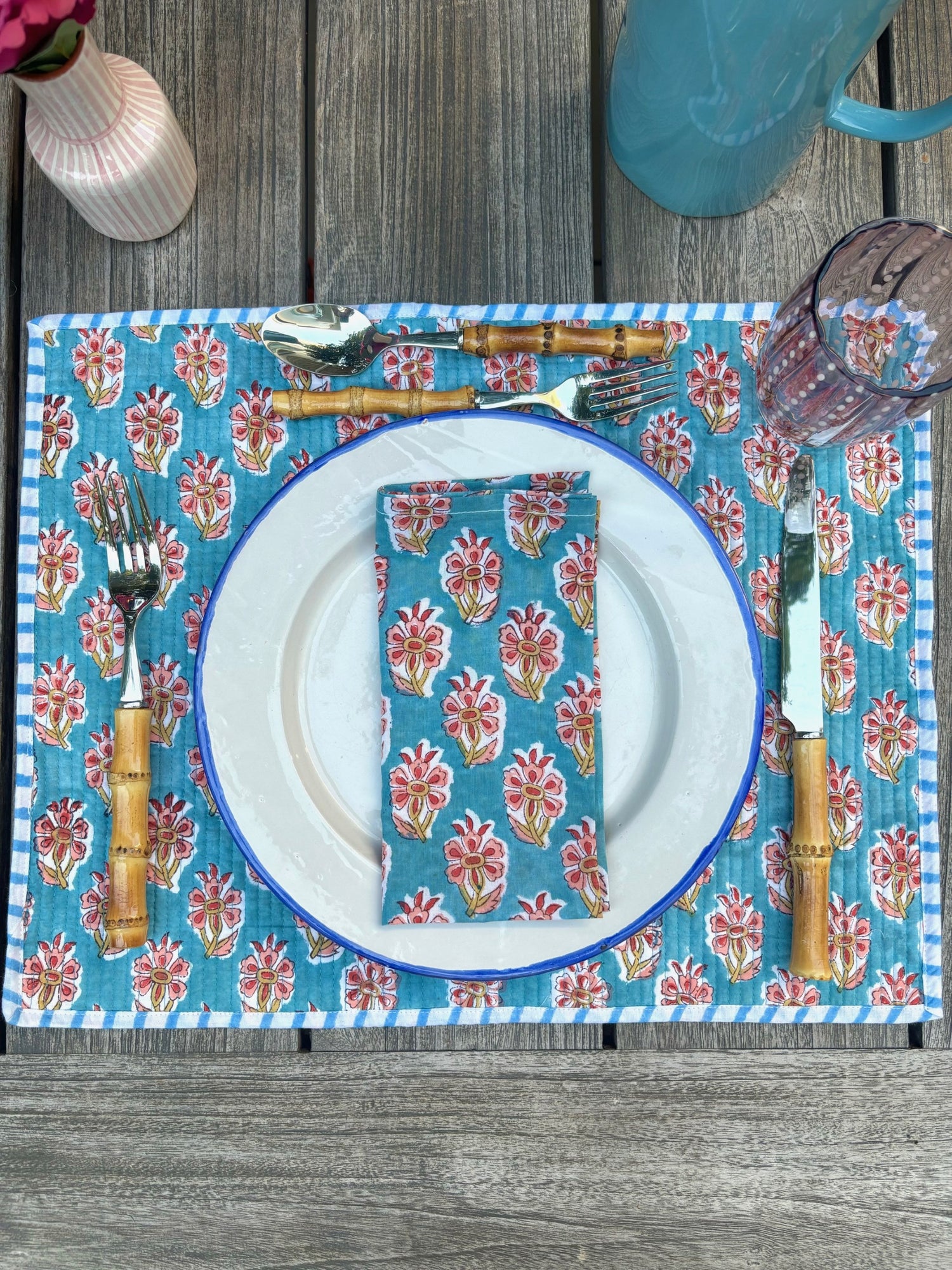 A place setting featuring a matching blue blockprint placemat and napkin set with bamboo cutlery