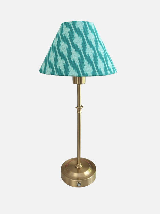 A rechargeable, cordless lamp with a handmade green ikat shade