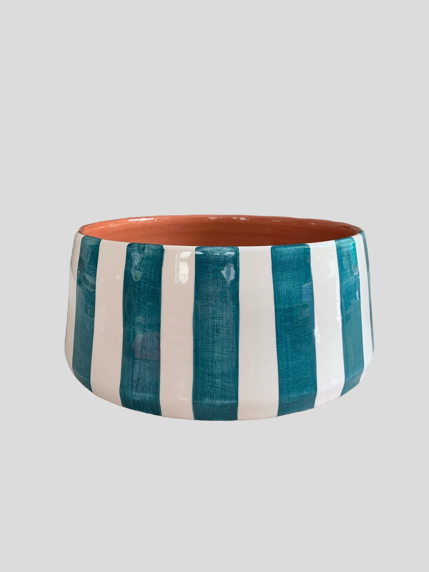 A ceramic tapered salad bowl hand-painted with bold, teal stripes from casa cubista in Portugal.