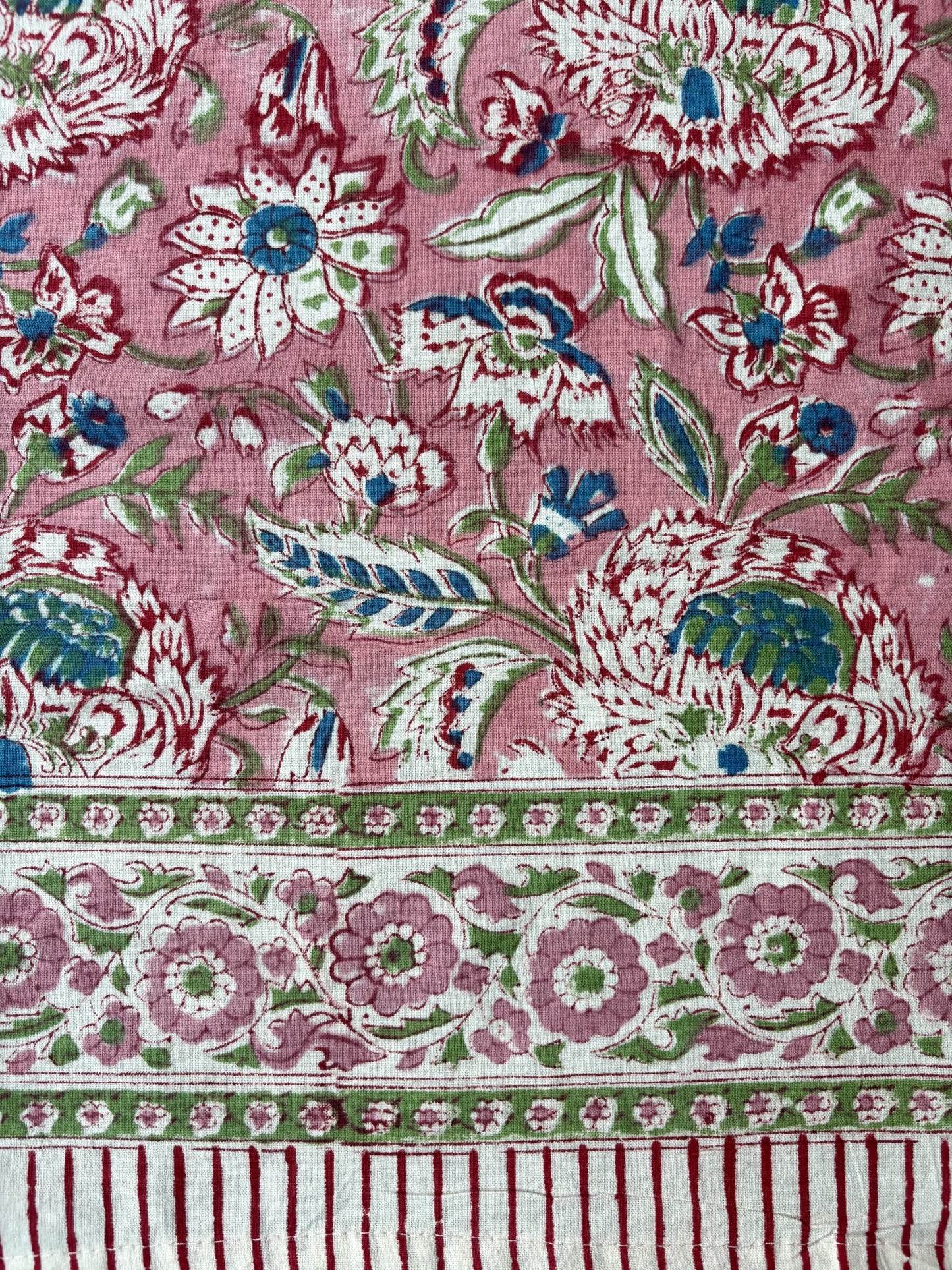 Decorative fabric with floral and striped patterns on a pink background