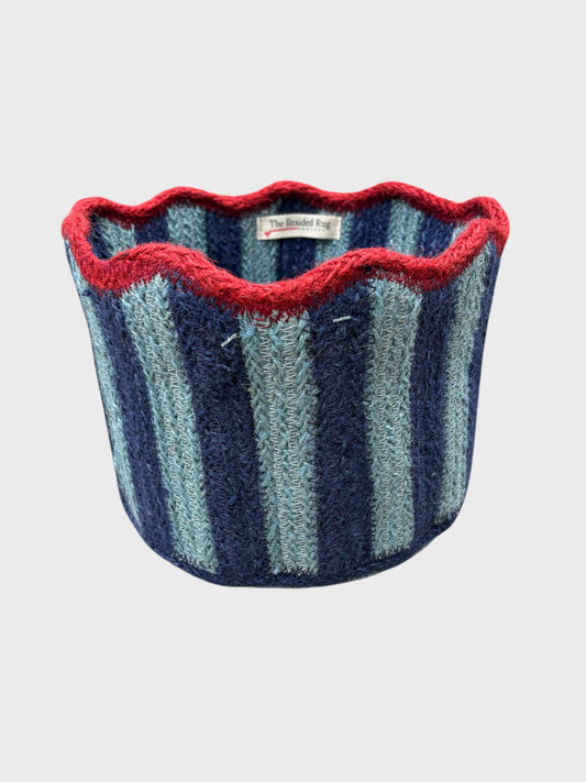 A pale blue and navy striped tulip basket with a red scallop