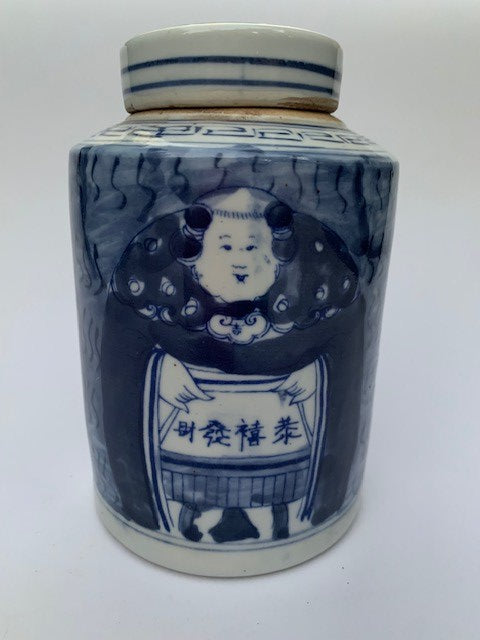 A blue and white ceramic tea jar with a picture of a fat lady on it symbolizing good fortune.