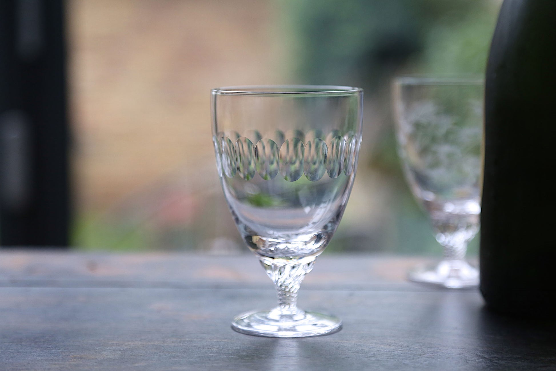 A French style bistro wine glass with an engraved band of connecting ovals.