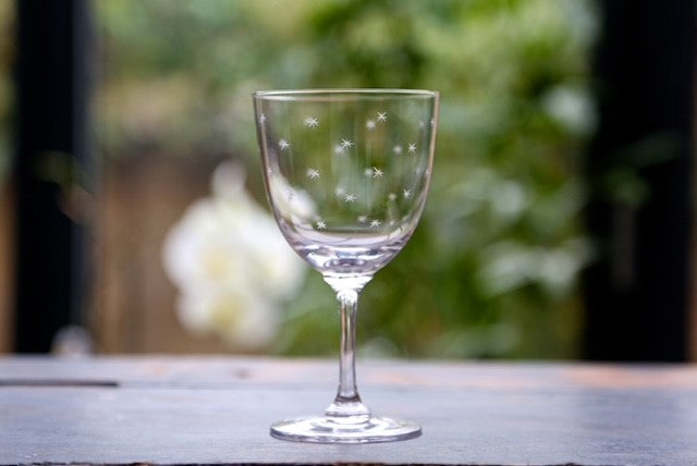 A crystal wine glass with etched stars