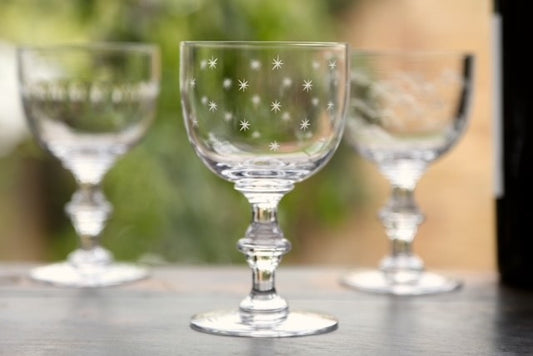 A crystal wine goblet with etched stars.