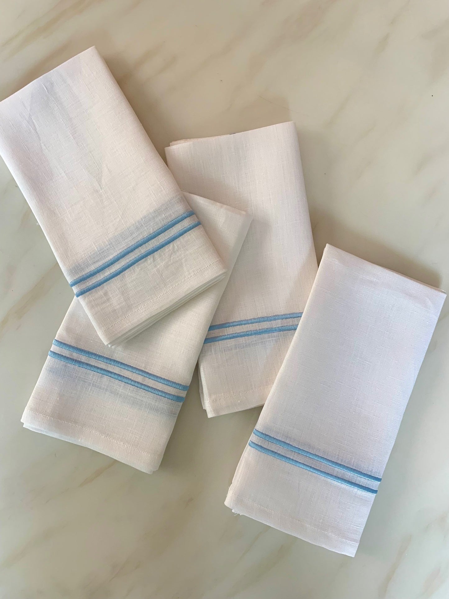 4 white linen napkins with sky blue double piping