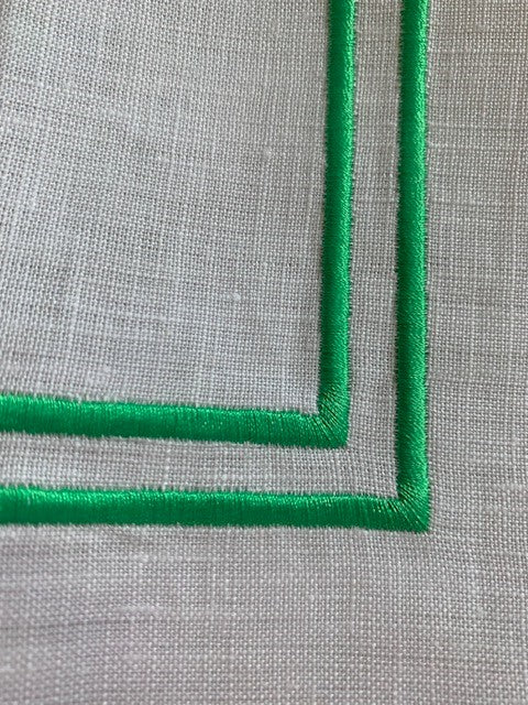 Double green piping on a white linen napkin