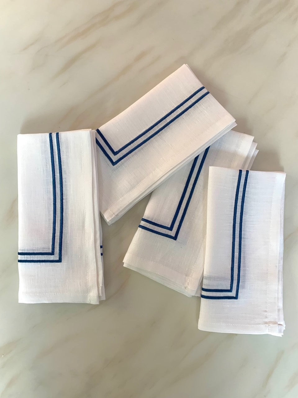4 white linen napkins with double piping in midnight blue