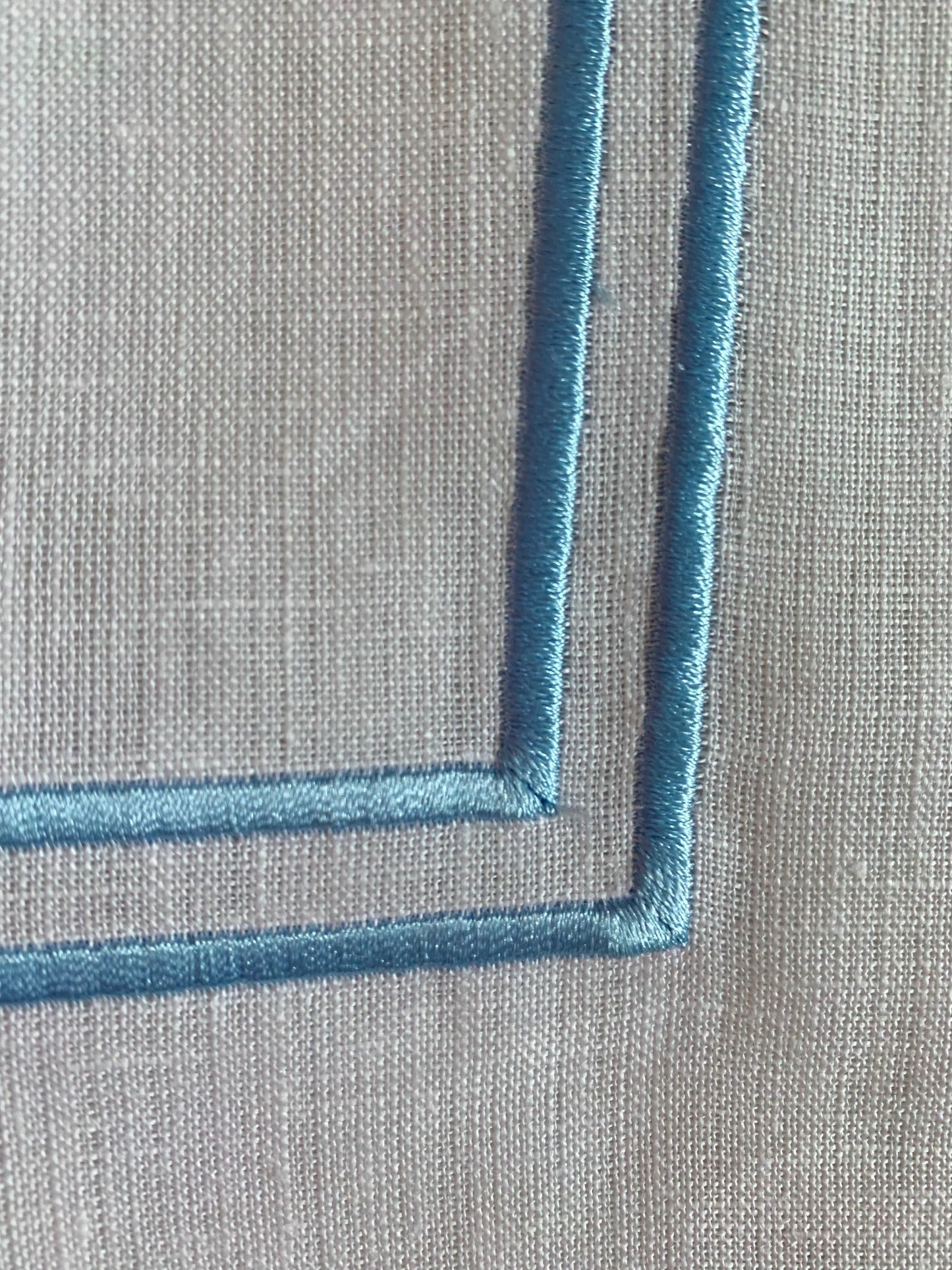 sky blue double piping on a white linen napkin