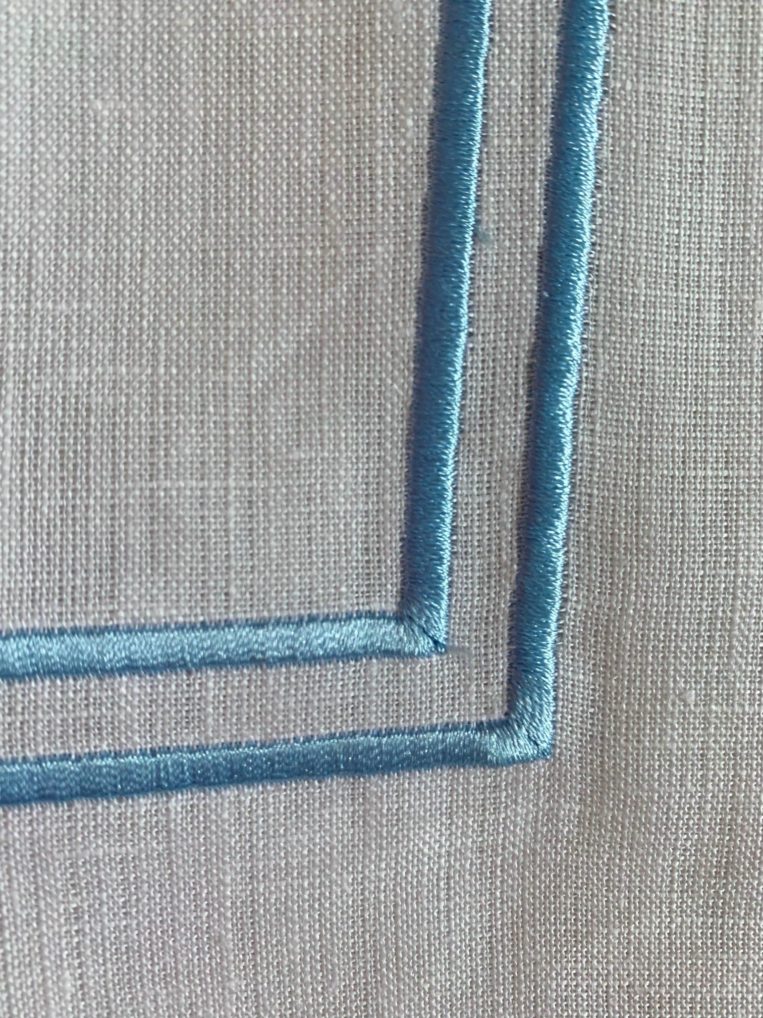 sky blue double piping on a white linen napkin
