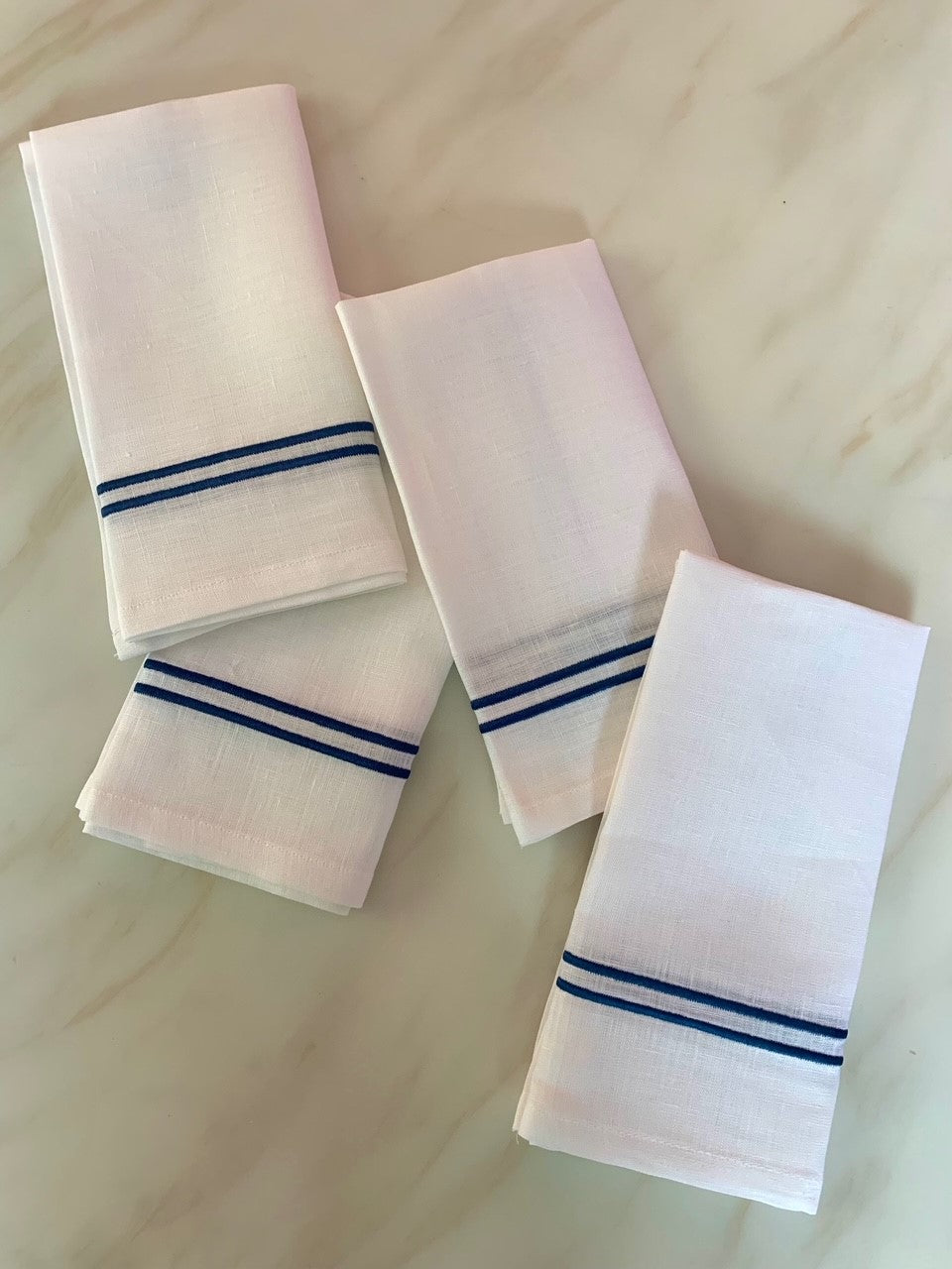 4 white linen napkins with midnight blue double piping